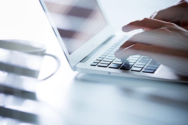 hands typing at computer