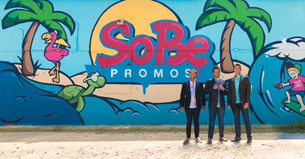 Sobe Promos Guys in Front of Logo