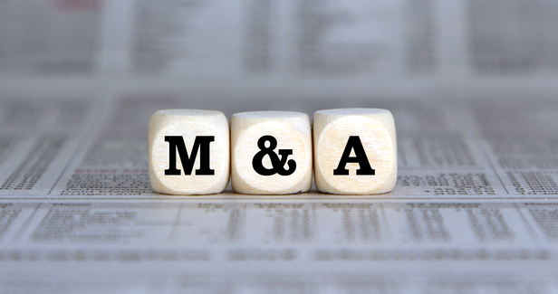 M&A on wooden blocks on top of newsprint