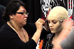 Makeup artist applying makeup to woman's face.