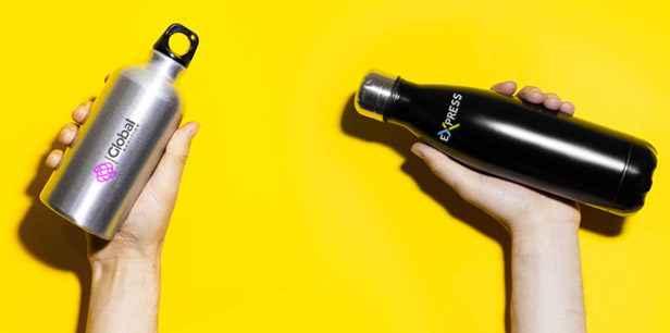 Hands holding up water bottles on yellow background