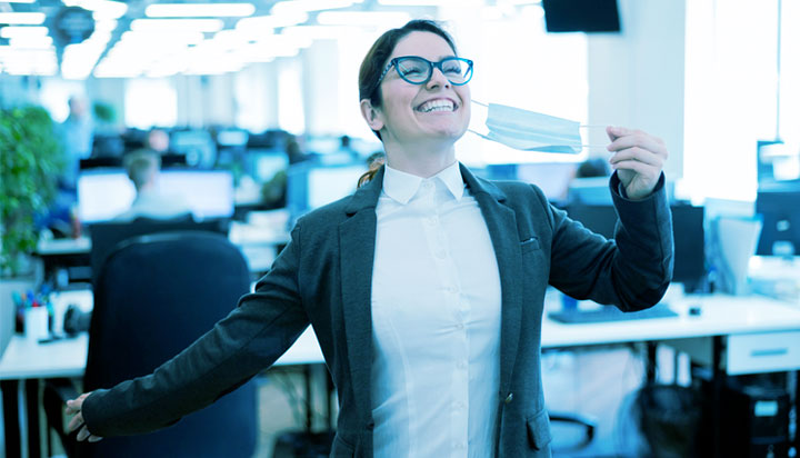 woman in office taking off mask