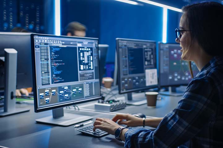 Young woman at computer coding