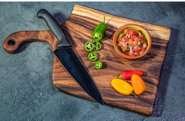 cutting board with peppers and knife on top