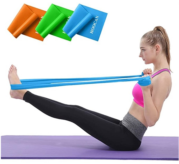 woman on yoga mat using resistance bands