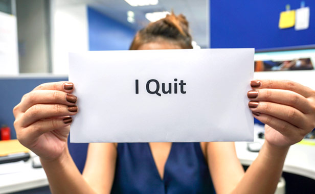 woman holding up a sign that reads I Quit