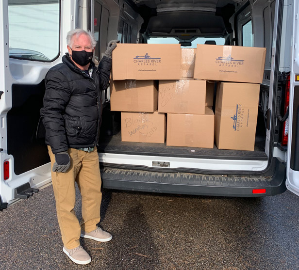 man standing next to donation boxes loaded in back of van