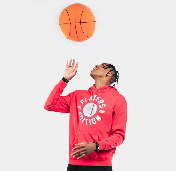 man wearing red hoodie twirling basketball