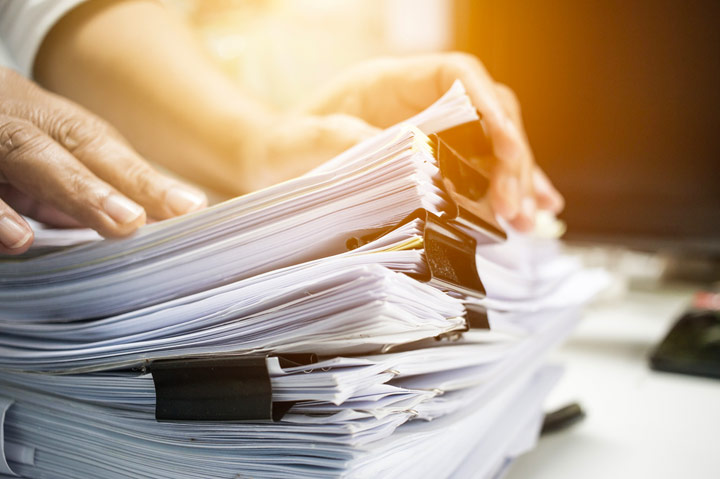 hand on stack of business papers