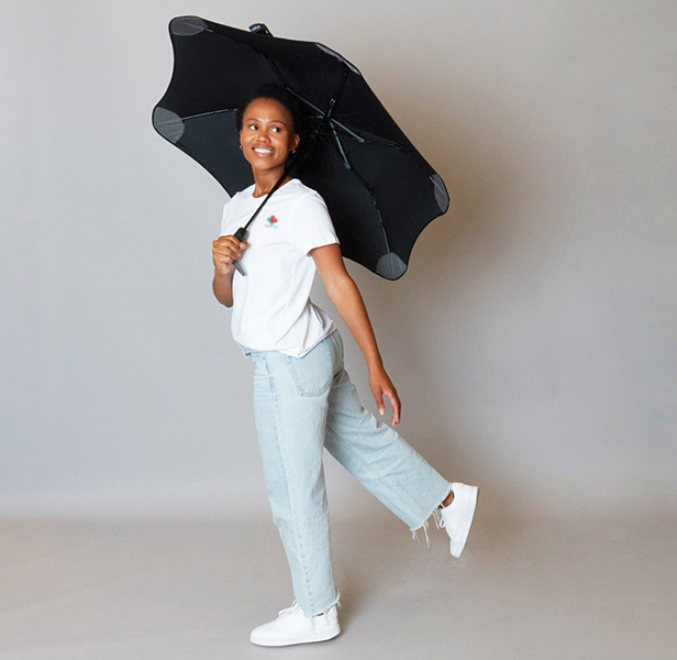 young woman holding black umbrella, smiling