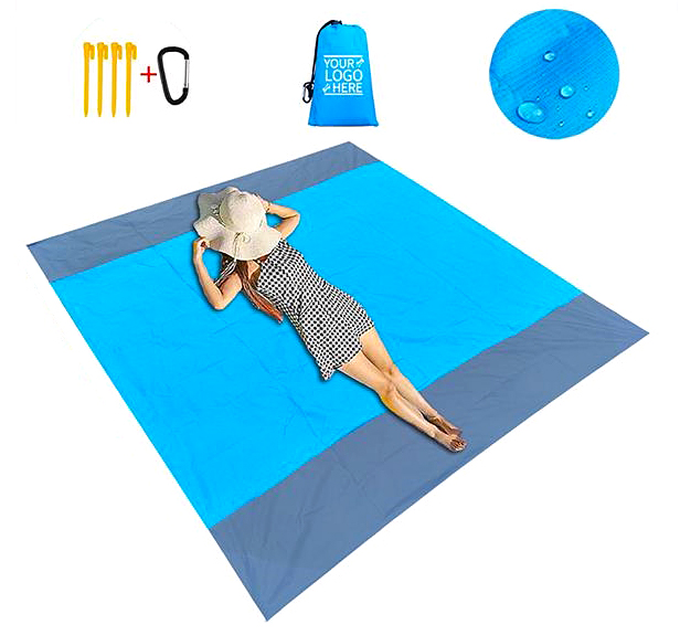 woman lying on blue picnic blanket with hat covering her face