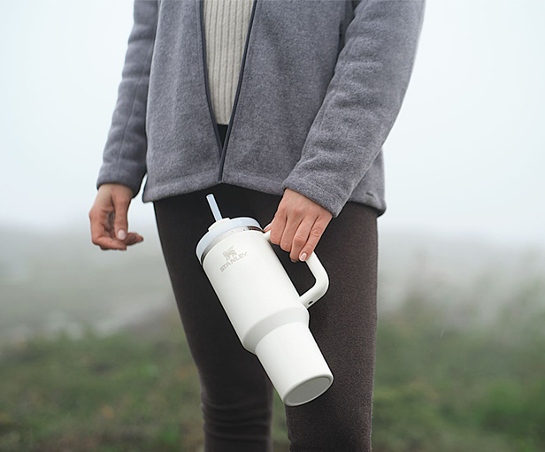 woman holding white Stanley tumbler