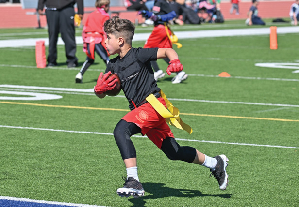 young boy playing flag football