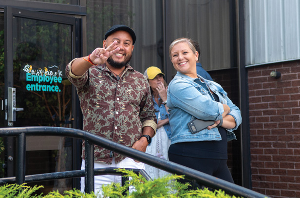 man giving peace sign, woman smiling