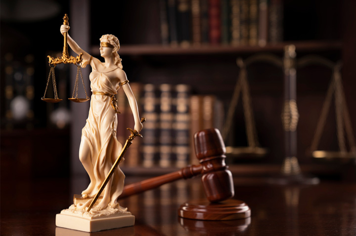 lady justice holding scales next to gavel