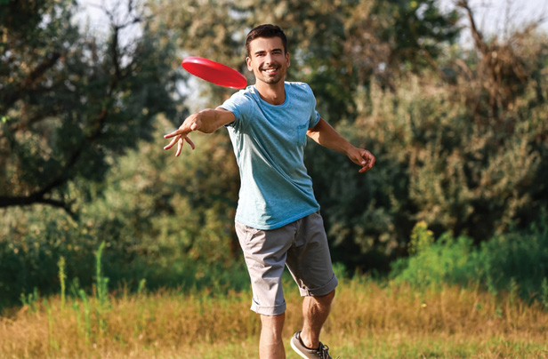 man throwing red frisbee